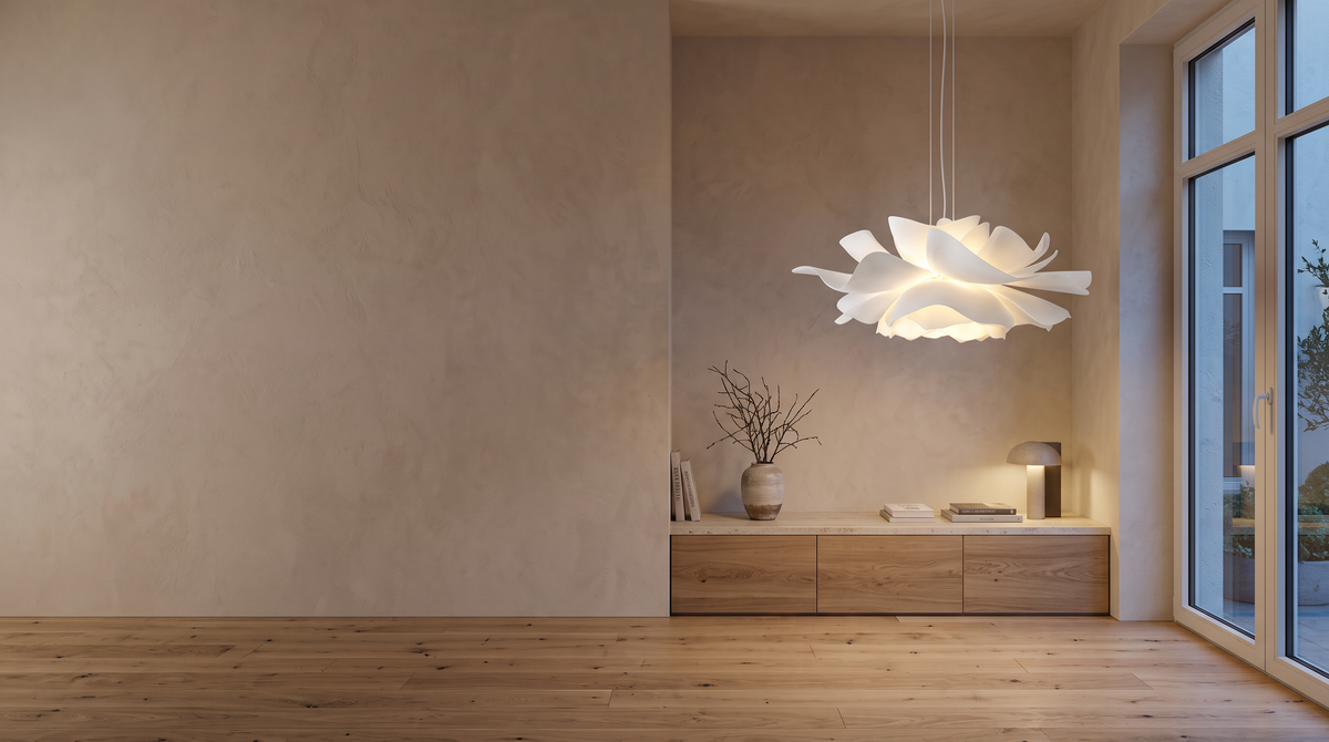 Modern European living room at dusk with a sculptural white Petal pendant glowing on the right and a calm plaster wall on the left